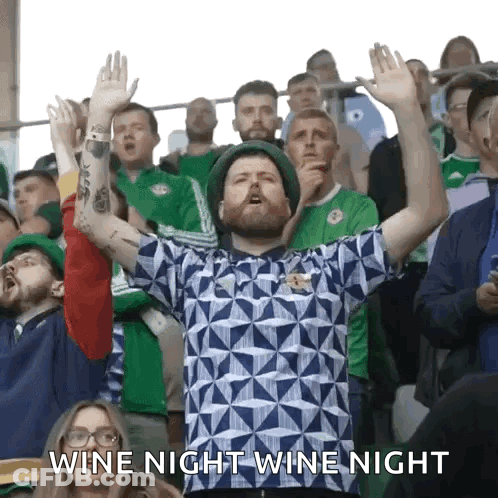 A Man In A Crowd With His Hands In The Air And The Words Wine Night Wine Night GIF