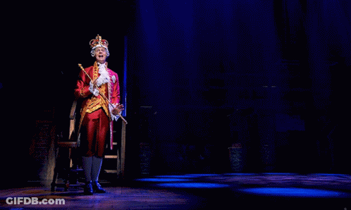 A Man In A Crown Is Holding A Cane GIF
