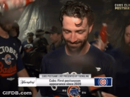 A Man In A Cubs Shirt Is Being Interviewed By A Reporter GIF