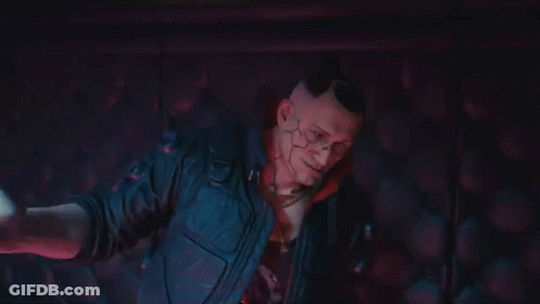 A Man In A Cyberpunk Suit Is Holding A Woman 'S Hand In A Dark Room . GIF