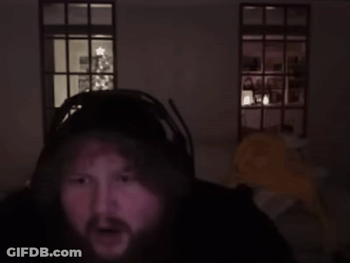 A Man In A Dark Room With A Christmas Tree In The Background Says Genius GIF