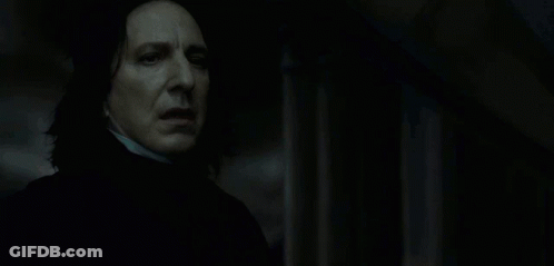 A Man In A Dark Room With A Glowing Light Behind Him GIF
