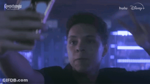 A Man In A Dark Room With A Goosebumps Logo In The Background GIF