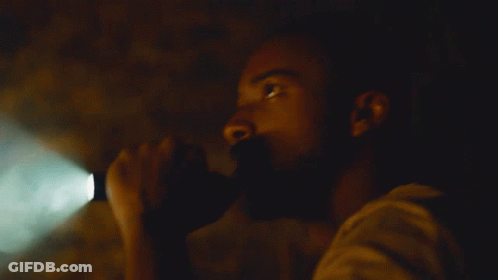 A Man In A Dark Room With A Green Light Shining On Him GIF