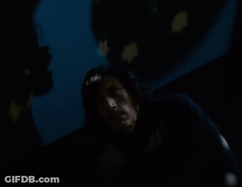 A Man In A Dark Room With A Star Projected On The Wall Behind Him GIF