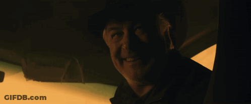 A Man In A Dark Room With His Mouth Open And His Tongue Sticking Out GIF