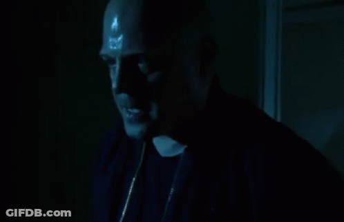 A Man In A Dark Room With Sweat Coming Out Of His Forehead GIF