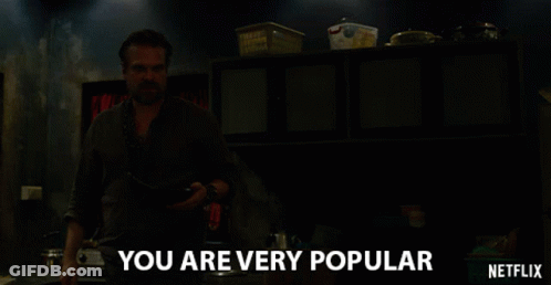 A Man In A Dark Room With The Words " You Are Very Popular " Above Him GIF