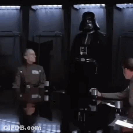A Man In A Darth Vader Costume Is Standing In Front Of A Group Of Men Sitting At A Table GIF