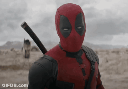 A Man In A Deadpool Costume Holding A Sword GIF