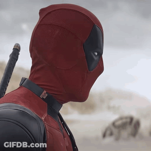 A Man In A Deadpool Costume Holds A Sword In His Hand GIF