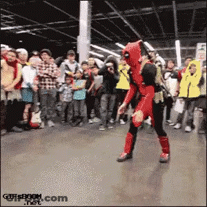A Man In A Deadpool Costume Is Dancing In Front Of A Crowd .. GIF