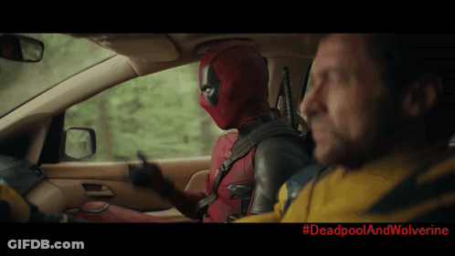 A Man In A Deadpool Costume Is Driving A Car Next To A Man In A Wolverine Jacket GIF