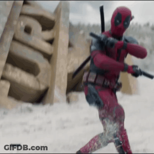 A Man In A Deadpool Costume Is Holding A Gun And A Sword In The Snow . GIF