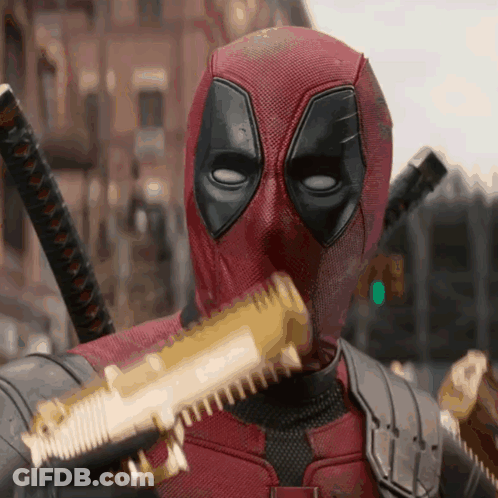 A Man In A Deadpool Costume Is Holding A Gun GIF