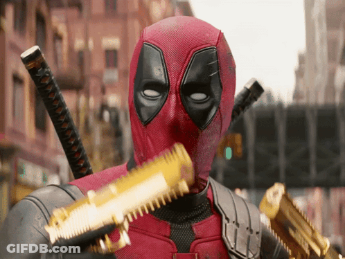 A Man In A Deadpool Costume Is Holding A Gun GIF