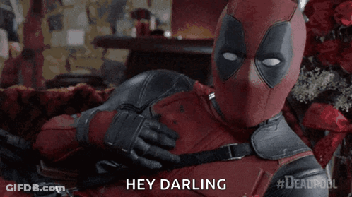 A Man In A Deadpool Costume Is Laying On A Bed And Saying Hey Darling GIF