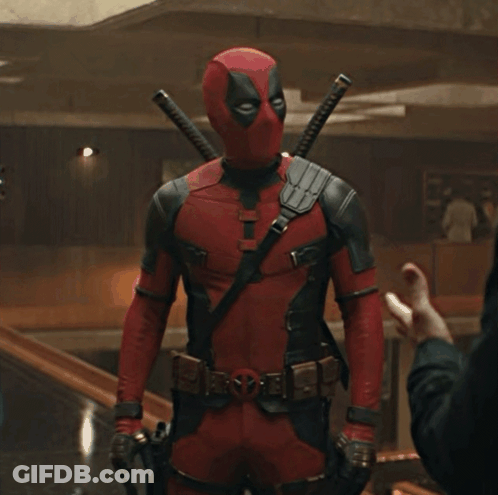 A Man In A Deadpool Costume Is Standing In A Room GIF
