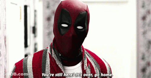 A Man In A Deadpool Costume Is Standing In A Room And Talking To Someone . GIF