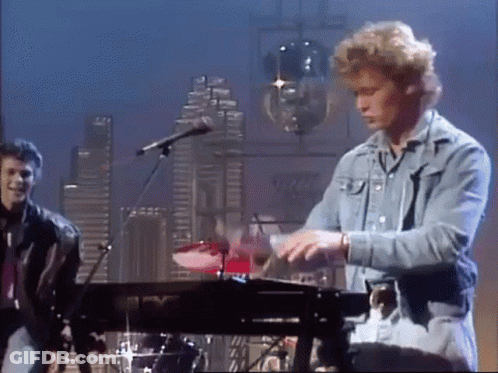 A Man In A Denim Jacket Is Playing A Keyboard GIF