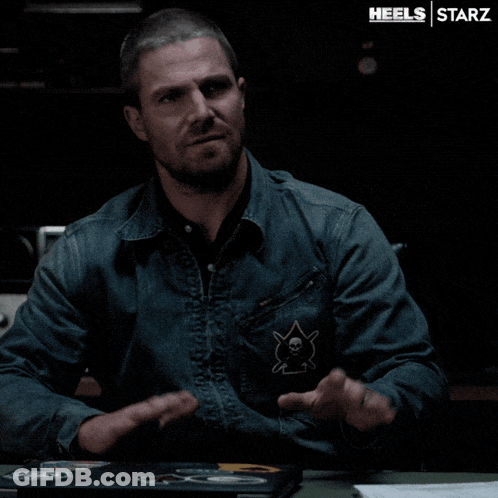 A Man In A Denim Jacket Is Sitting At A Table With A Laptop On It And The Words Heels Starz On The Bottom GIF