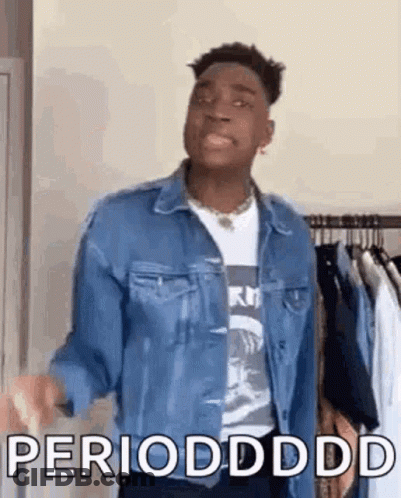 A Man In A Denim Jacket Is Standing In Front Of A Clothes Rack And Says Periodddd . GIF