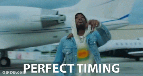 A Man In A Denim Jacket Is Standing In Front Of An Airplane With The Words Perfect Timing Written On The Bottom GIF