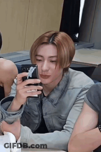 Man In Denim Jacket Taking Selfie GIF