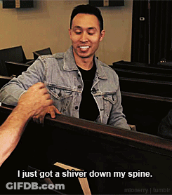 A Man In A Denim Jacket Is Talking To Another Man In A Black Shirt GIF