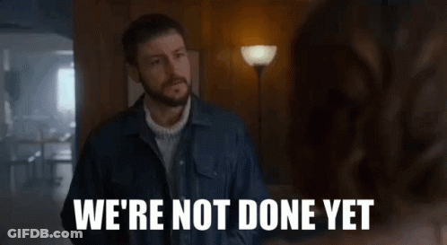 A Man In A Denim Jacket Says " We 'Re Not Done Yet " To A Woman GIF