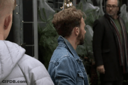 A Man In A Denim Jacket Stands Next To Another Man In A Suit GIF