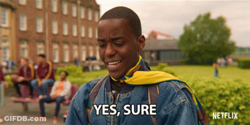 A Man In A Denim Jacket With A Yellow Scarf Around His Neck Says " Yes Sure " GIF