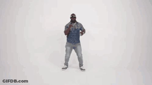 A Man In A Denim Shirt And Jeans Is Dancing In Front Of A White Background . GIF