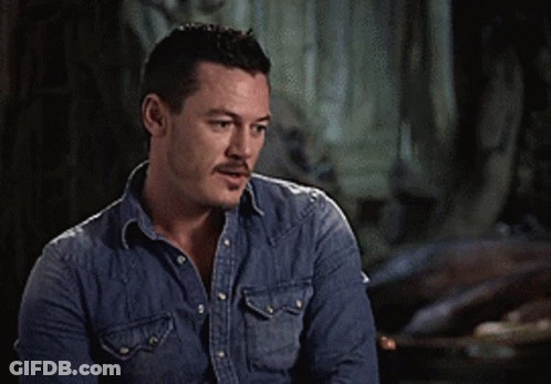 A Man In A Denim Shirt Is Making A Peace Sign With His Hands GIF