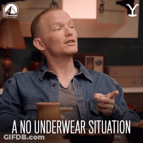 A Man In A Denim Shirt Is Sitting At A Table With A No Underwear Situation Written Below Him GIF