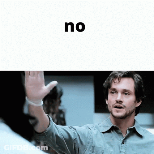 A Man In A Denim Shirt Is Waving His Hand In Front Of The Word No GIF