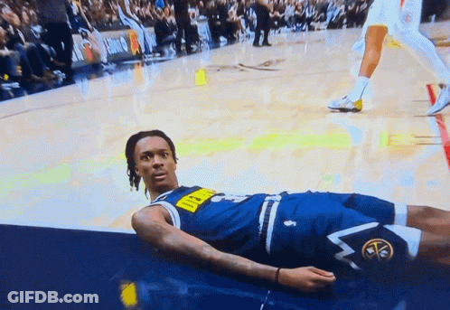 A Man In A Denver Nuggets Uniform Lays On The Floor GIF
