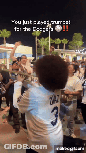 A Man In A Diaz Jersey Plays Trumpet In Front Of A Crowd GIF