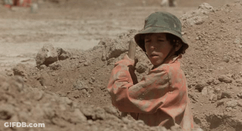A Man In A Dirty Shirt Is Sitting On The Ground GIF