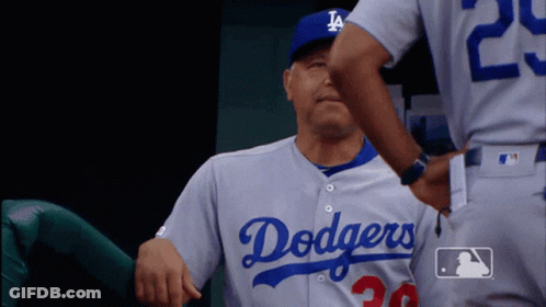 A Man In A Dodgers Jersey Is Being Hugged By Another Man GIF