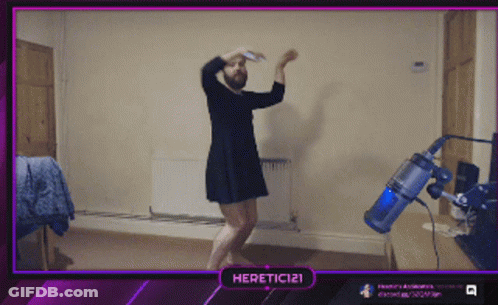 A Man In A Dress Is Dancing In Front Of A Vacuum Cleaner And A Purple Border That Says Heretic121 GIF