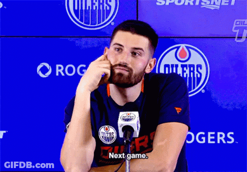 A Man In A Edmonton Oilers T-Shirt Talks Into A Microphone GIF