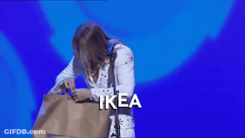 A Man In A Elvis Costume Is Holding A Bag With The Word Ikea On It GIF