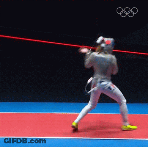 A Man In A Fencing Uniform Is Standing On A Red And Blue Court . GIF