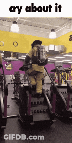 A Man In A Fire Suit Is Riding A Treadmill In A Gym And The Caption Says Cry About It GIF