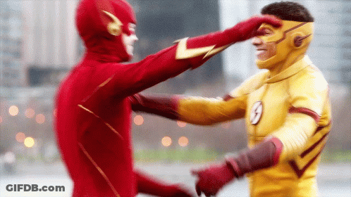 A Man In A Flash Costume Is Touching Another Man 'S Face GIF