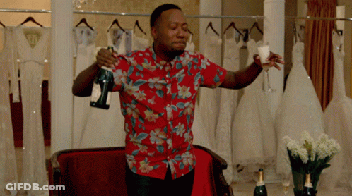 A Man In A Floral Shirt Holds A Bottle Of Champagne And A Glass GIF