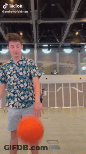 A Man In A Floral Shirt Is Holding A Basketball In His Hand And A Tiktok Watermark Is Visible GIF