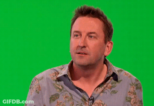 A Man In A Floral Shirt Is Waving His Hand In Front Of A Green Screen GIF