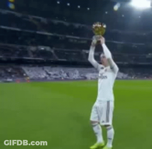 A Man In A Fly Emirates Shirt Is Holding A Trophy GIF
